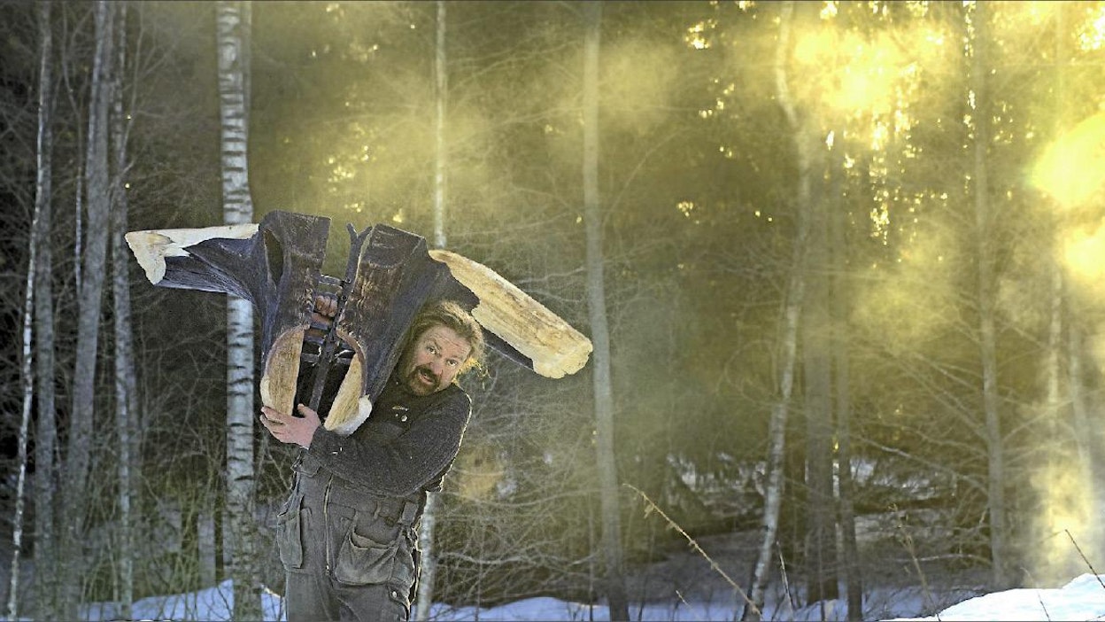 Seppo Kalliokoski kantaa harteillaan puusta ja raudasta tekemäänsä Laumanjohtaja-teosta. Esko Keski-Vähälä