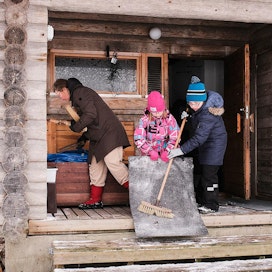 Reena Laukkanen-Abbey laittelee yhdessä lapsiensa Melissa ja Roni Baltzarin kanssa retkikämpän saunaa käyttökuntoon.