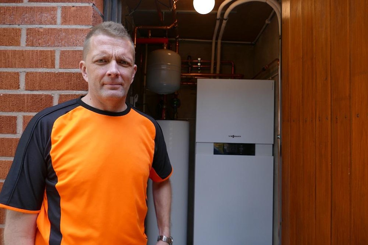 Mika Leiviskä on tyytyväinen, että vaihto öljylämmityksen ilma-vesilämpöpumppuun. Hänen takanaan olevasta sisäyksiköstä säädetään esimerkiksi kodin lämpötila.