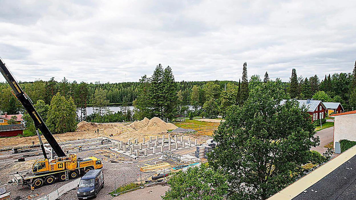 Uusien rakennusten on tarkoitus sointua Hyytiälän metsäaseman historialliseen miljööseen. Kuvan oikeassa laidassa puun takaa pilkistää punainen 110-vuotias Impivaara.