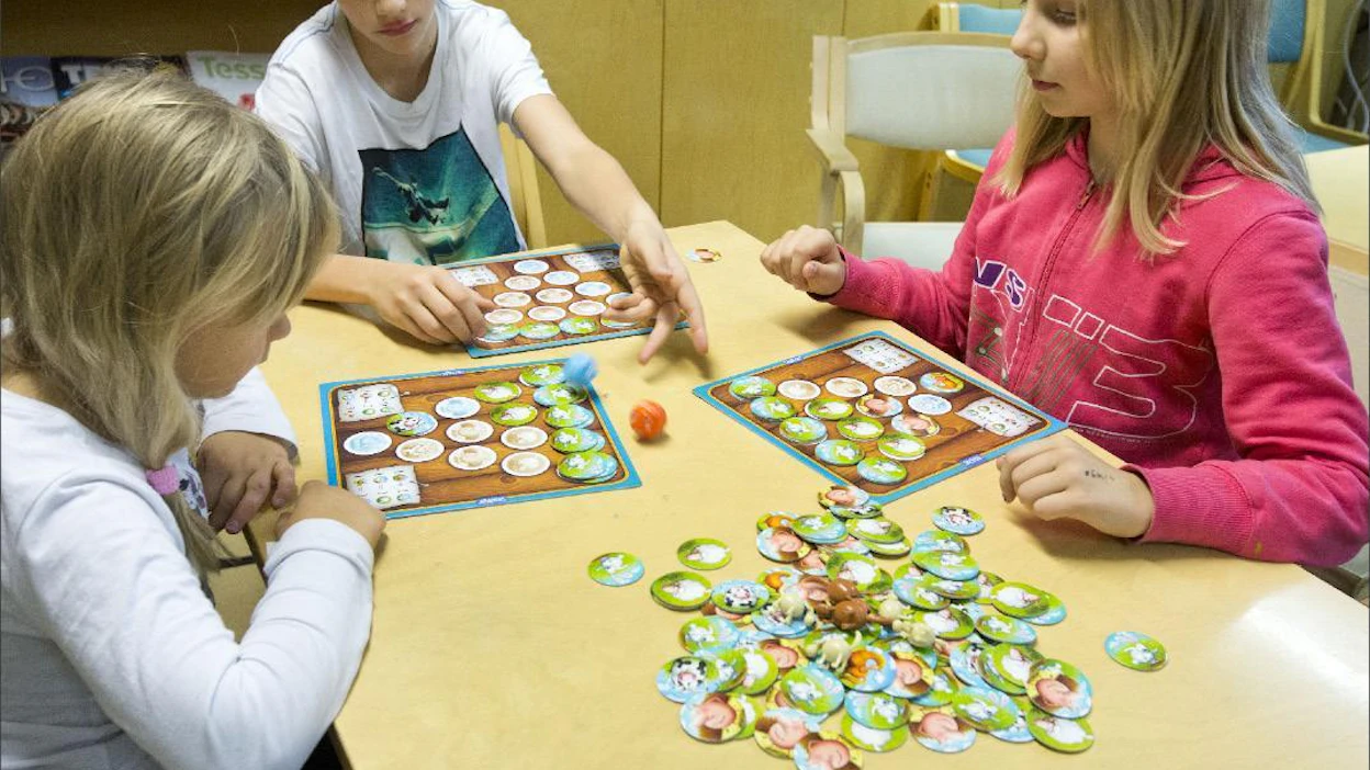 Nettipelit koukuttavat, mutta lautapelitkin pitävät pintansa. Superfarmaria koepelanneiden Anna (vas.), Onni ja Helmi Poutasen mielestä peli tarjoaa sopivasti jännitystä. Markku Vuorikari