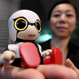 Pieni Kirobo-robotti mahtuu kehdossaan auton kahvitelineeseen.