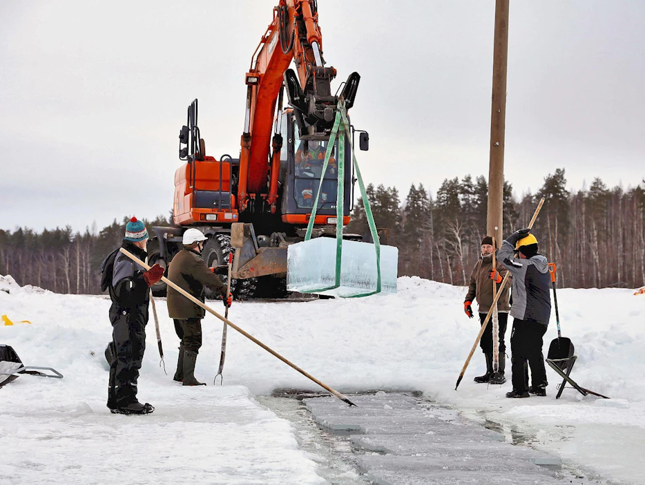 Sahatut jääharkot uitetaan lähelle rantaa ja nostetaan kaivurilla rannalla odottaville kuormalavoille. Matka jääveiston kisoihin voi alkaa.