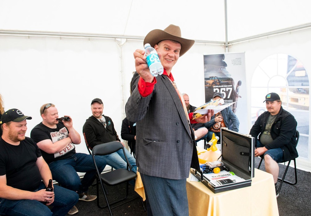 Tuomo Sipilä esittelee maksuvälineenä toiminutta vesipulloa.