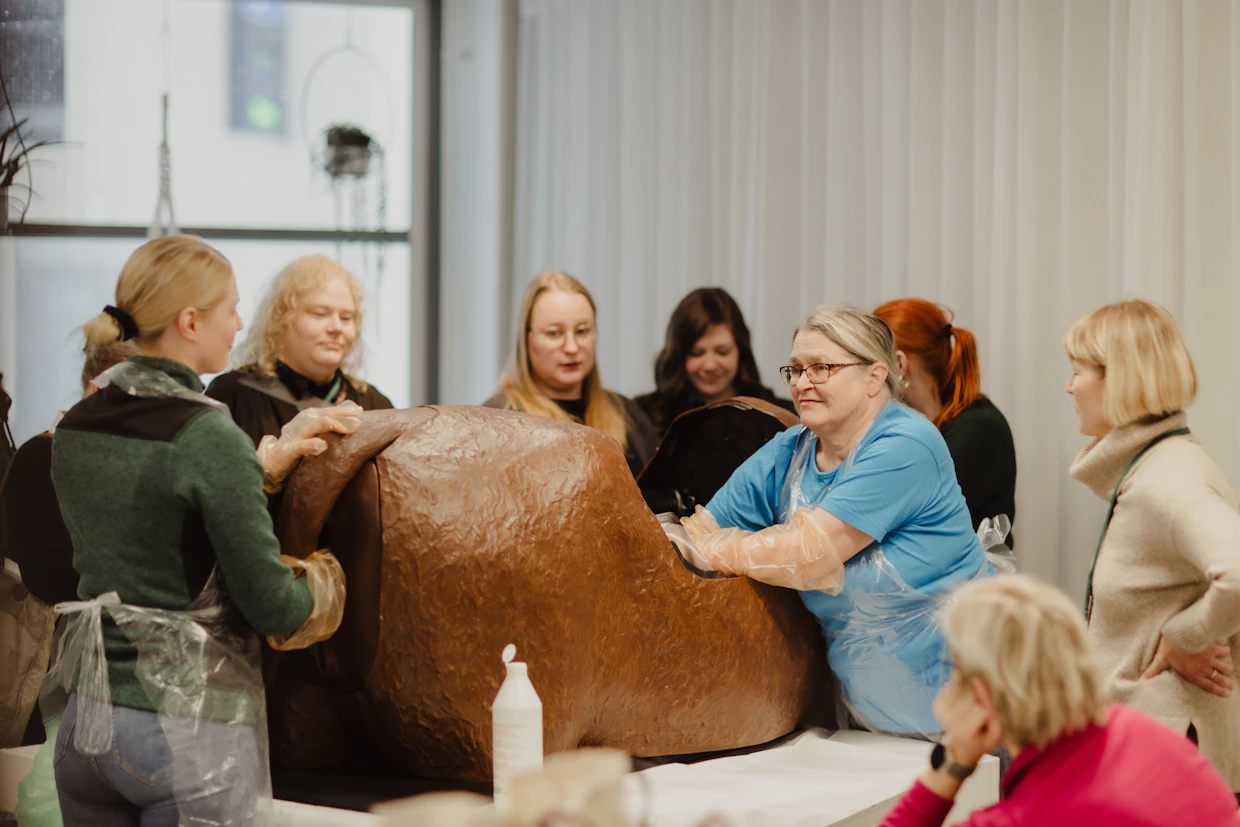 Lehtori Hilkka Kämäräinen sinisessä paidassaan opasti maitoseminaarilaisia vasikan virheasentojen havaitsemisessa.