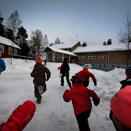Lapset juoksivat espoolaisen koulun pihamaalla talvipäivänä helmikuussa 2018. Kuvituskuva.