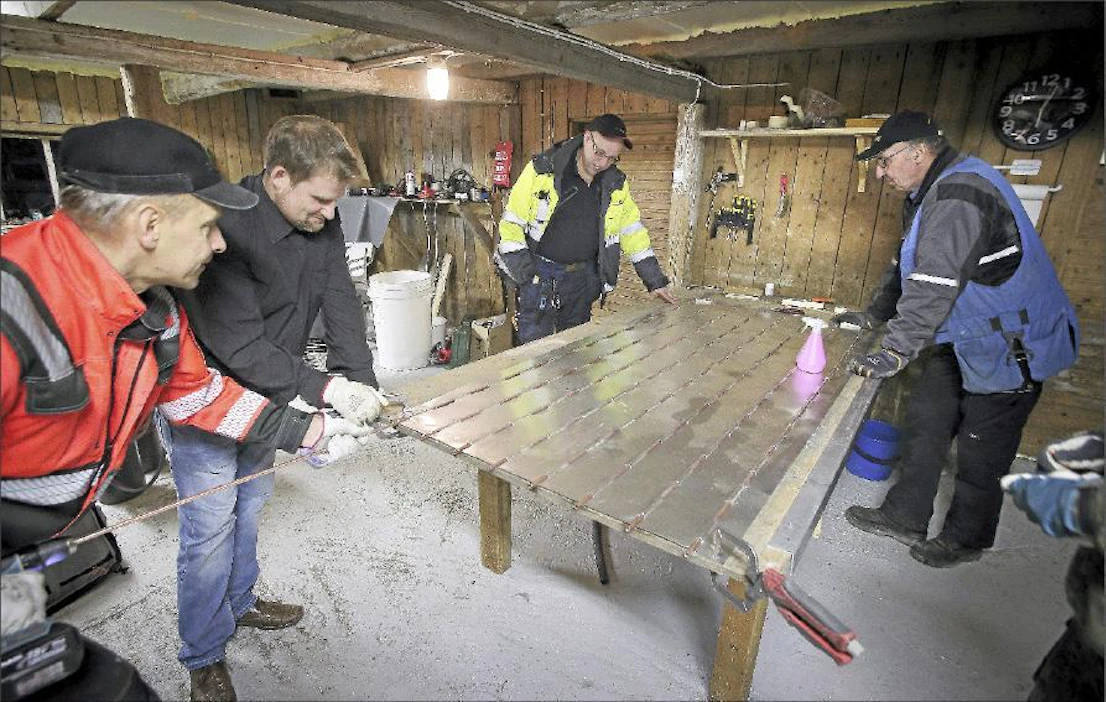 Keijo Hissa (vas.), Timo Rinne, Seppo Kinnari ja Jussi Nuuja pujottelevat aurinkolämpökeräimen kupariputkia alumiinilevyyn. Johannes Tervo