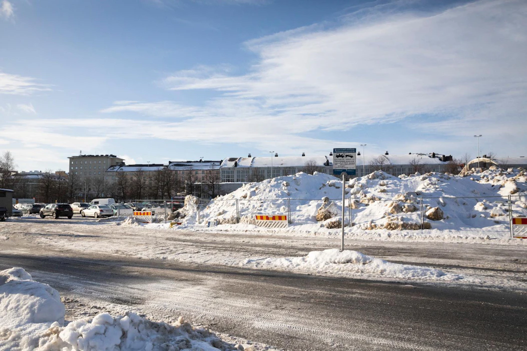 Lumikuorma toisensa perään odottaa kuljetusta Olympiastadionin pysäköintialueelta Helsingissä.