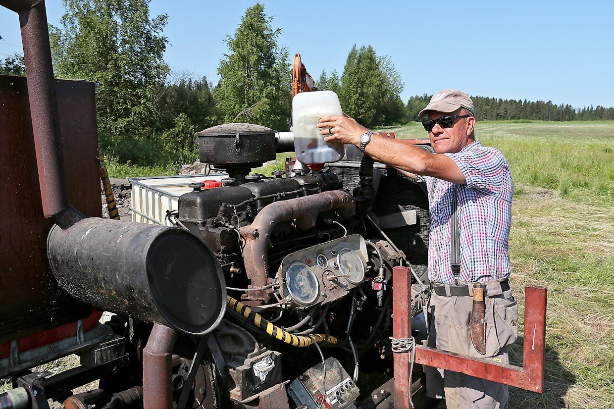 Antti Sarvela lisäämässä öljyä pumppua pyörittävään, vanhasta betoniautosta otettuun Scanian moottoriin. Pumppu itsessään on 1970-luvun peruja, mutta muutoin traktorilla hinattava pumppuyksikkö on varojärjestelmiä myöden oman pajan tuotoksia.
