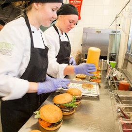 Janita Eklund ja Ellen Blechingberg valmistavat hampurilaisia avokeittiössä. Hampurilaisia valmistetaan vain tilauksesta ja ne noudetaan suoraan keittiön tiskiltä.
