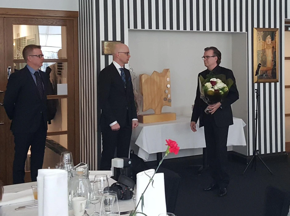 Puuteollisuusyritys ry:n hallituksen puheenjohtaja Ilkka Turpiainen ja toiminnanjohtaja Janne Liias onnittelevat Hatrick Oy:n toimitusjohtajaa Sakari Niemelää.