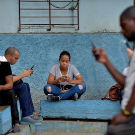 Kuuban pääkaupungissa Havanassa ihmiset pääsivät keskiviikkona puhelimillaan nettiin puistoon asennetun wifin avulla. LEHTIKUVA/AFP
