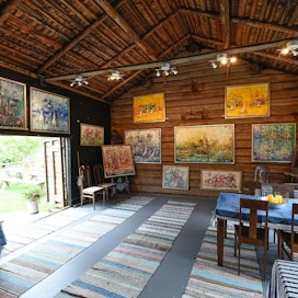 Vanhasta ladosta kunnostettiin ateljee, jossa riippuvat taiteilija Sari Haapaniemen värikylläiset maalaukset.