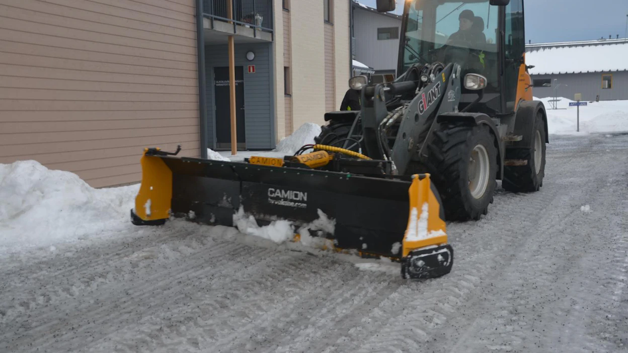 Zoom-aura on kätevä pihoissa. Peruskoneen kanssa ei tarvitse siirtyä sivuttain, kun levenevällä auralla päästään koukkaamaan sohjot myös katoksien alta. Zoom-auran ongelma on levityssylinterin ympärille pakkautuva lumi, jos lunta kaavitaan peruutettaessa.