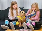 Matleena Mäki ja pikkusisko Mirjami Mäki lukivat ääneen lukukoira Leonalle syyslomalla Seinäjoen kirjastossa.