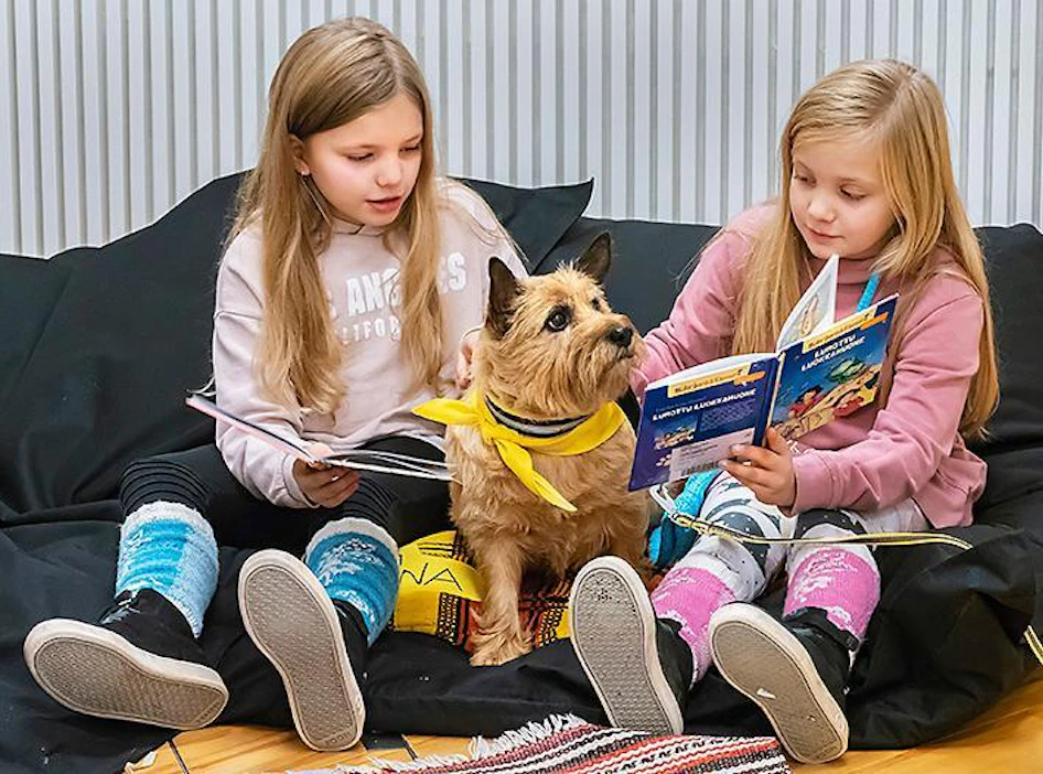 Matleena Mäki ja pikkusisko Mirjami Mäki lukivat ääneen lukukoira Leonalle syyslomalla Seinäjoen kirjastossa.