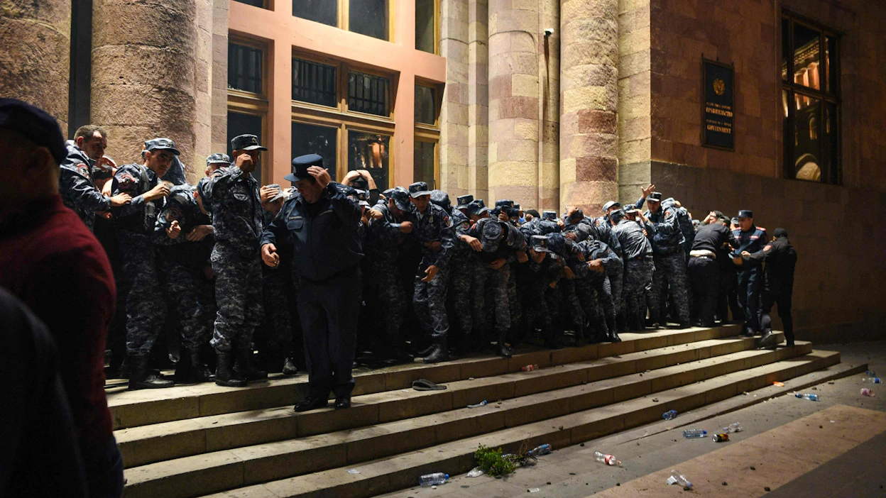 Armenialaiset poliisit vartioivat hallintorakennuksen sisäänkäyntiä tiistaina Jerevanissa, kun mielenosoittajien kanssa puhkesi yhteenottoja. LEHTIKUVA/AFP.