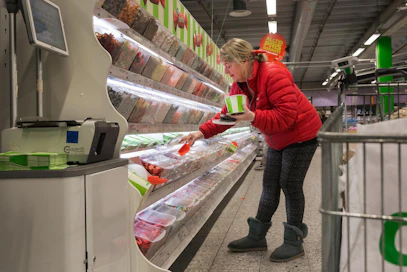 Tukholmalainen Helen pyyhki ostoskärryn käsipidikkeen saniteettipyyhkeellä ja kauhoo irtokarkkeja kumihanskat kädessä. "En ole muuttanut ostoskäyttäytymistäni. Vähän ylimääräistä kipulääkettä olen ostanut."