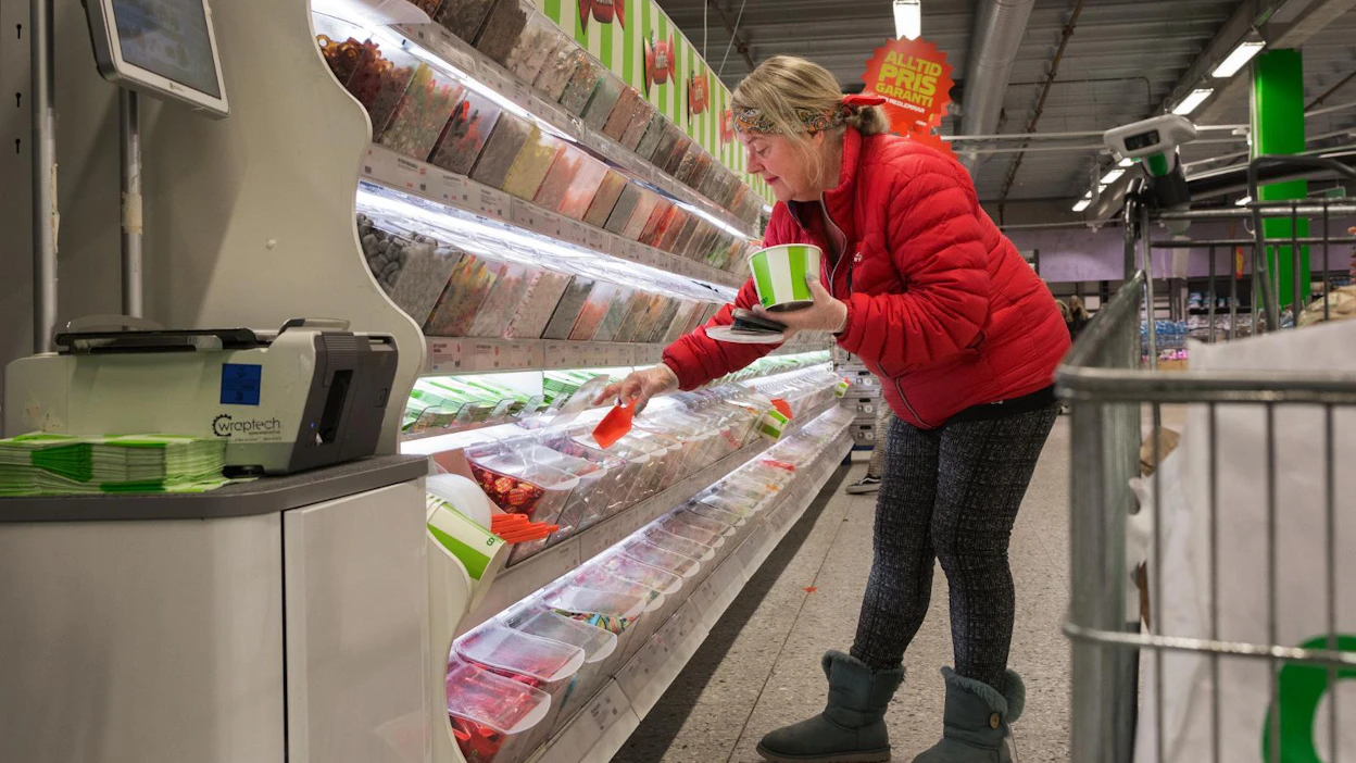 Tukholmalainen Helen pyyhki ostoskärryn käsipidikkeen saniteettipyyhkeellä ja kauhoo irtokarkkeja kumihanskat kädessä. "En ole muuttanut ostoskäyttäytymistäni. Vähän ylimääräistä kipulääkettä olen ostanut."