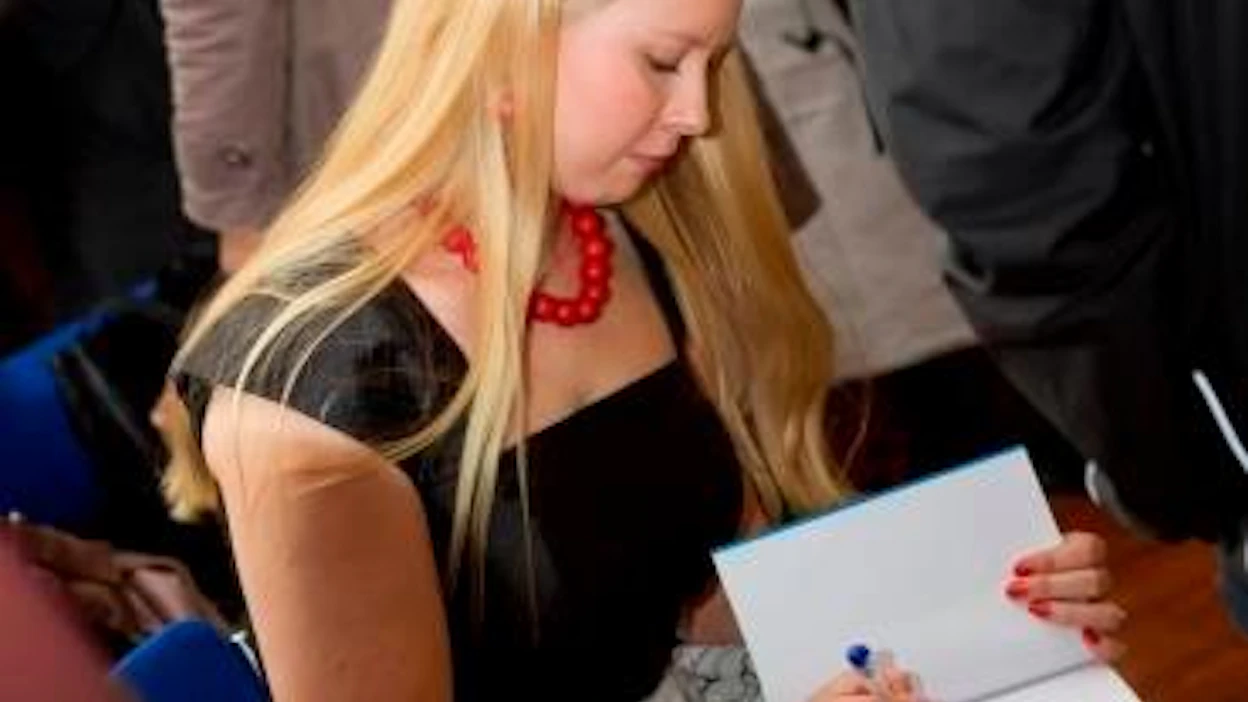 Elina Lappalaisen kirja Nakki lautasella julkaistiin tänään tiistaina. Kuvassa Lappalainen signeeraa edellistä kirjaansa Syötäväksi kasvatetut.