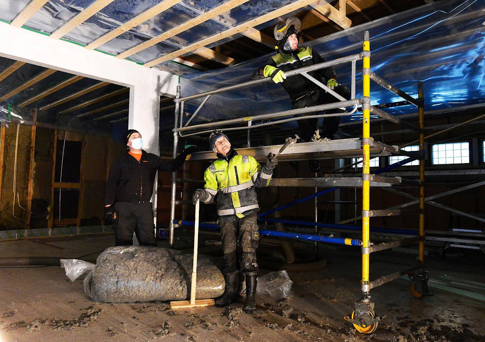 Tapio Räihä, Pentti Keskikukko ja Hannu Niemelä villoittavat 1970-lukulaisen kaupparakennuksen välikattoa Rautiossa Kalajoella. Osuuskunnan hallinnoima kauppa sijoittuu taloon, jossa toimi Osuuskauppa KPO:n myymälä viime maaliskuun loppuun asti.