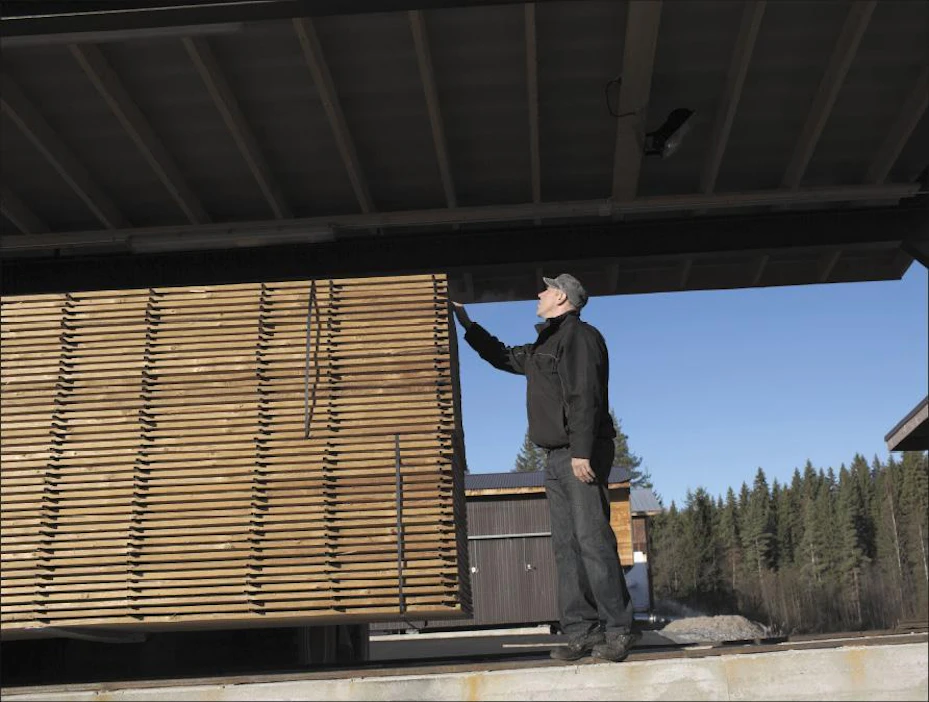 Rimat pois välistä, nauhat ympärille ja vientiin. Jarkko Salo silmäilee lämpöpuunippua, joka on valmis lähtemään asiakkaalle. Käsittelyssä ollut 25 x 200 millimetrin kuusitavara menee Saksaan. Saara Olkkonen