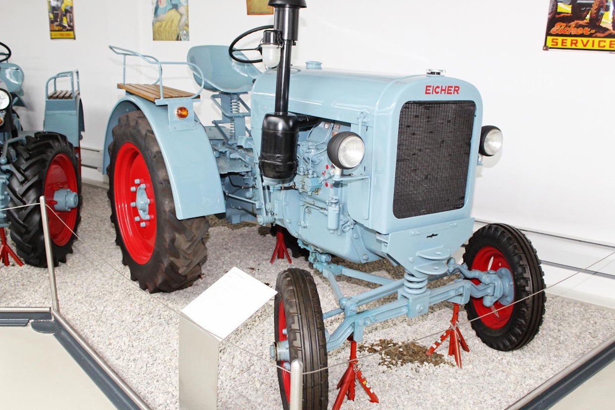 Vuonna 1936 traktorituotannon aloittanut Eicher kuului 1950- ja 60-luvuilla Länsi-Saksan viiden myydyimmän merkin joukkoon, mutta jatkossa pistesijat jäivät saavuttamatta. Viimeinen saksalainen Eicher valmistui vuonna 1998. Kuvan E22 oli ensimmäinen sarjatuotettu Eicher-traktori, sitä tehtiin välillä 1938–50 noin 1 100 kpl. Moottori on 2-pyttyinen Deutz-diesel, vaihteistona aluksi Prometheus, vuodesta 1945 lähtien ZF. (Paderborn)