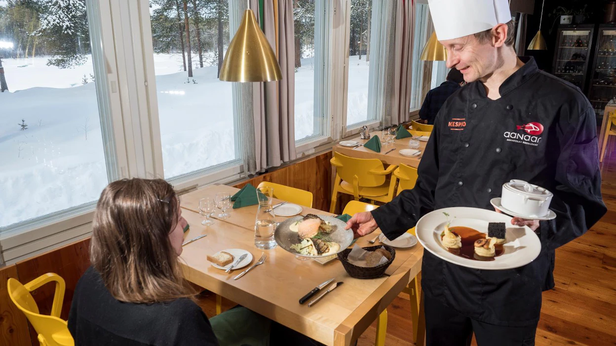 Keittiömestari Heikki Nikula tarjoilee toimittajalle grillattua Inarin siikaa ja poron kumpuksia. Arkistokuva.