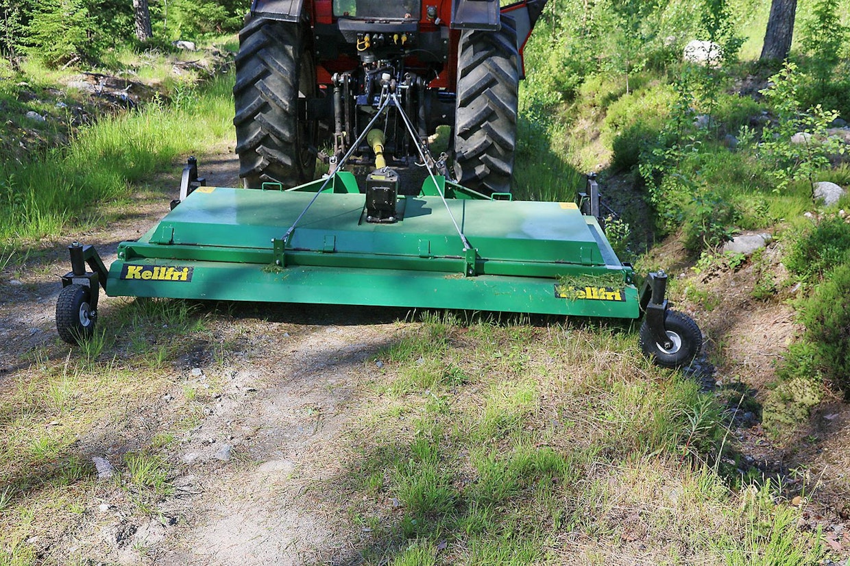 Takana kulkevan leikkurin etu on se, että esimerkiksi mökkitien keskikohdan heinikko ja pajunvesat ovat niitettävissä. Pyöräsarjalla kone rullaa kevyesti traktorin perässä. Kun siirtää leikkurin sivurajoittimilla aivan sivuun, saa myös tienpenkereen niitettyä, kunhan konetta kannattelee nostolaitteella.