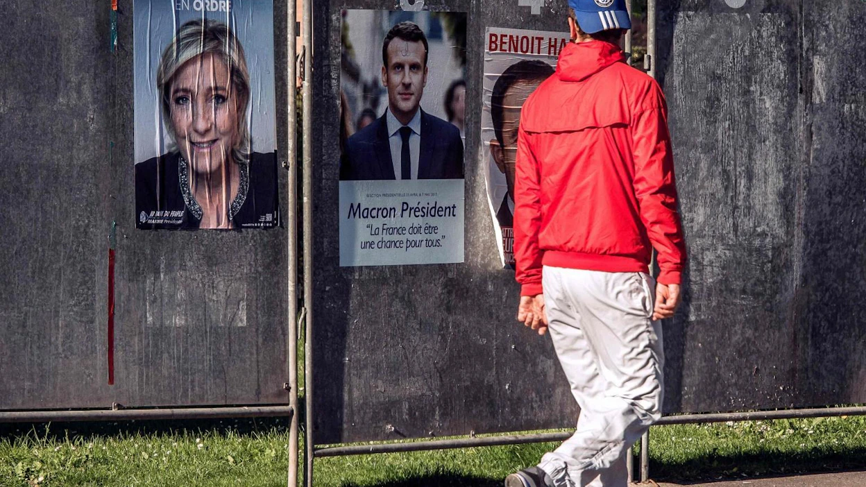 Mies käveli Ranskan presidentinvaalien julisteiden ohitse Luoteis-Ranskan Henin-Beaumontissa aiemmin tällä viikolla. LEHTIKUVA/AFP