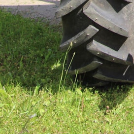 Traktoreilla on päädytty Pihtiputaalla nurmikon puolelle. Kuvituskuvaa.