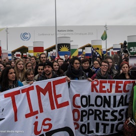 Mielenosoittajat vaativat maailman päättäjiltä tiukempia päästöleikkauksia Pariisin ilmastokokouksessa vuonna 2015.