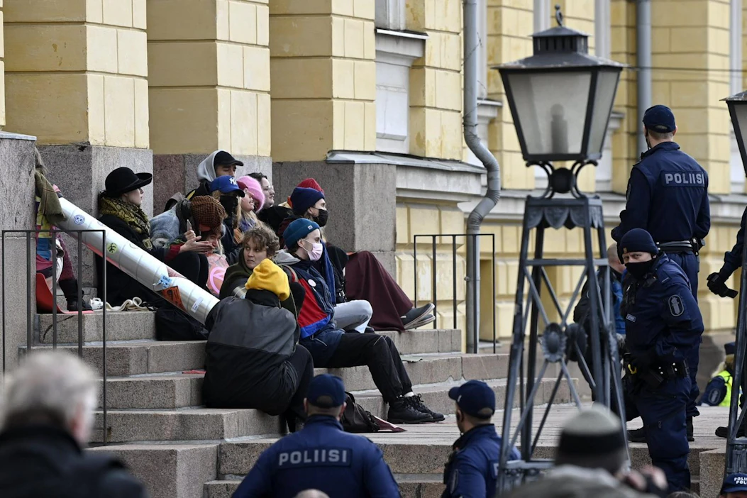 Ympäristöliike Elokapina lukittautui Valtioneuvoston linnan edustalle perjantaina.