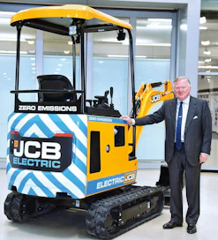 JCB hallituksen puheenjohtaja Lord Bamford esittelee JCB:n ensimmäistä sähkökäyttöistä kaivinkonetta.