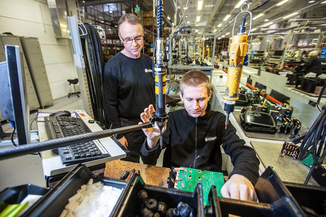 Kemppi Oy:ssä on tällä hetkellä neljä harjoittelijaa. Materiaalinkäsittelijä (vas.) Kari Sipilä toimii työnopastajana, kun Nuutti Immonen, 16, ensimmäisen vuoden kone- ja tuotantotekniikan opiskelija Salpauksesta, kokoonpanee hitsauskonetta.