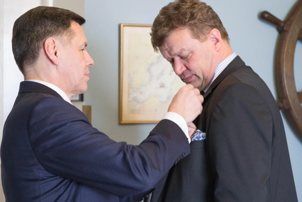 Suomen Sotaveteraaniliiton toiminnanjohtaja Sakari Martimo kiinnittää ansiomitalia päätoimittaja Jouni Kemppaisen rintaan.