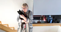 Anneli Kannon sylissä on Timo Orvokki -kissa. ”Pikimustat kissat olivat aikoinaan noitien kissoja”, omistaja toteaa.   kuva: Rami marjamäki