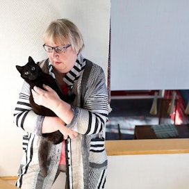 Anneli Kannon sylissä on Timo Orvokki -kissa. ”Pikimustat kissat olivat aikoinaan noitien kissoja”, omistaja toteaa.   kuva: Rami marjamäki