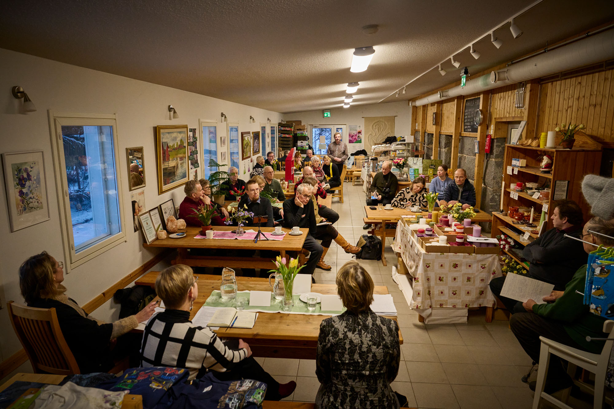 Topin Maatilamyymälän pöydissä kuunneltiin keskittyneesti kun maidontuottaja Jarmo Nykänen (takana seisaallaan) kertoi tuottajakentän vakavia tunnelmia. Kuvassa etualalla selin panelistit Sari Essayah (oikealla), Krista Mikkonen ja Susann Rännäri. 