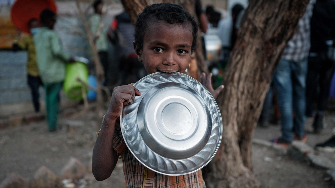 Etiopiassa Tigrayn alueen väkivaltaisuuksia paennut lapsi odotti tiistaina päivän ainoaa ateriaa koulussa, jonne on majoitettu yli 7000 ihmistä. LEHTIKUVA/AFP. 
