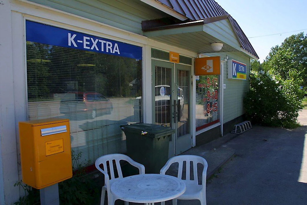 K-Extra kyläkauppa jonka yhteydessä myös posti-palvelut. Kauppias Harri Kuokka kantaa kauppaan kurkku ja tomaatti-laatikoita.HUOM! Kauppa lopettanut toimintansa 2004.