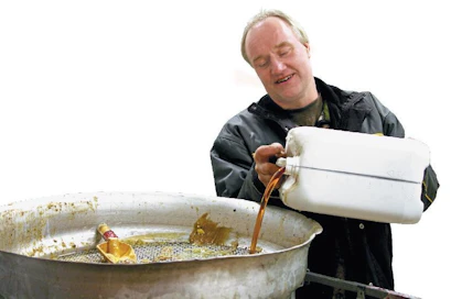 Ilkka Sjöholm seuloo epäpuhtaudet pois rasvasta ennen kuin se pumpataan reaktoriin.