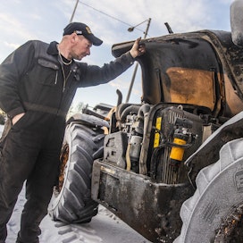 Suomen Konehuolto Oy:n omistaja Mikko Vanha-Kuitti tutkii traktoria, jonka kone täytyy vaihtaa pakkasen aiheuttamien vaurioiden vuoksi.