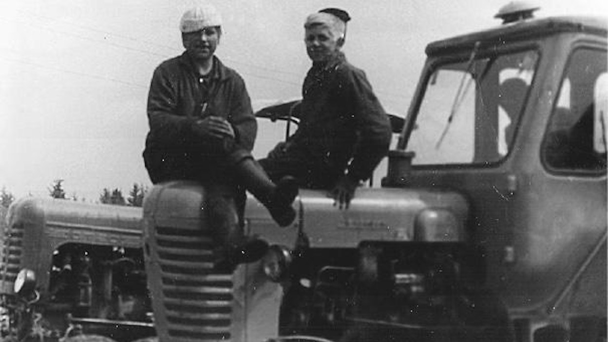 Leonid Nuija (kuvassa oikealla) aloitti uransa hatsinalaisen sovhoosin traktoristina 70-luvun alussa. Ensimmäinen ajokki oli takana näkyvä HTZ DT-20, jonka ohjaimiin Leonid pääsi suoritettuaan 1-vuotisen kuljettajakurssin. ”Täystuhoa” käytettiin heinätöihin, perunamaiden haraamiseen, perunoiden aumaamiseen sekä talvisin lajittelijan pyöritykseen.