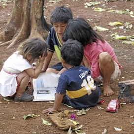 Lapset tutkivat tietosanakirjaa, jonka joku on jättänyt kylään. Riitta Mustonen