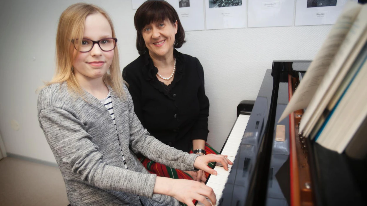 Liisa Turkkila on opetellut soittamaan Keski-Suomen kotiseutulaulua pianotunneilla opettajansa Katriina Orbinskin opastuksella.