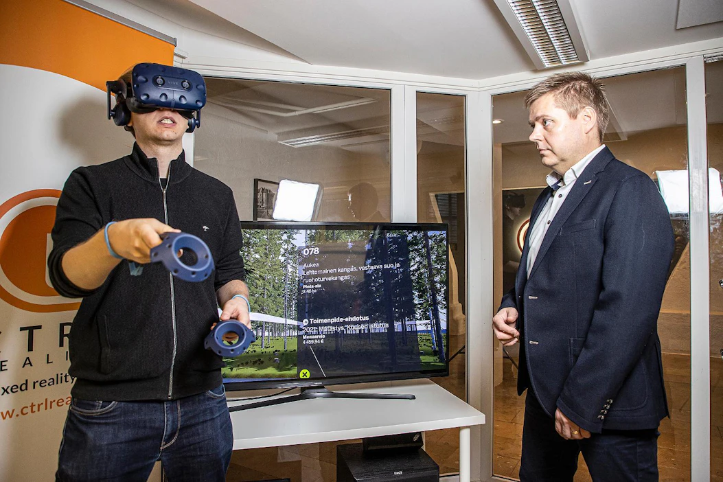 CTRL Realityn tuotepäällikkö Timo Korkalainen (vas.) tutustui virtuaalimetsään VR-lasien avulla. Toimitusjohtaja Teijo Lehtonen näki samalla ruudulta, missä päin palstaa liikutaan ja millaista metsänhoitotoimenpidettä kuviolle ehdotetaan seuraavaksi.