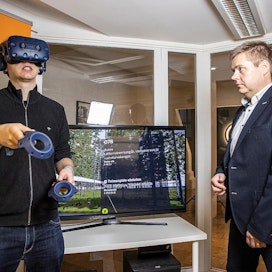 CTRL Realityn tuotepäällikkö Timo Korkalainen (vas.) tutustui virtuaalimetsään VR-lasien avulla. Toimitusjohtaja Teijo Lehtonen näki samalla ruudulta, missä päin palstaa liikutaan ja millaista metsän­hoitotoimenpidettä kuviolle ehdotetaan seuraavaksi.