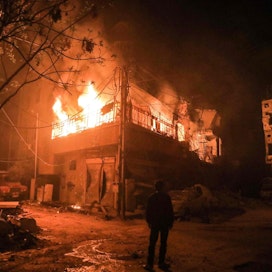 Syyrialaismies seisoo palavan rakennuksen luona Itä-Ghoutan yössä. Hallitus hyökkäsi taannoin Douman kaupunginosaan, joka on viimeisten joukossa kapinallisten hallussa.