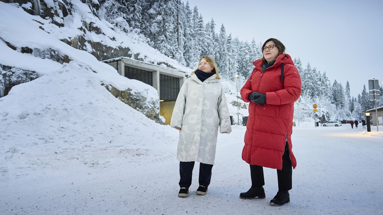 Irma Savolainen (vas.) ja Kati Partanen seisovat Kuopion uuden liikuntatila–väestönsuoja Luolan suuaukolla.